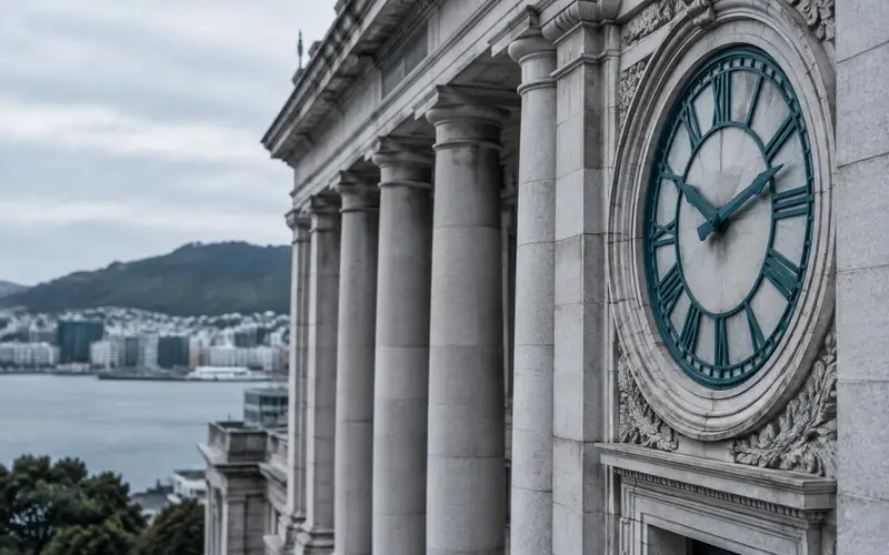 A civic colonnade in Wellington with no people and a round clock set in the facade