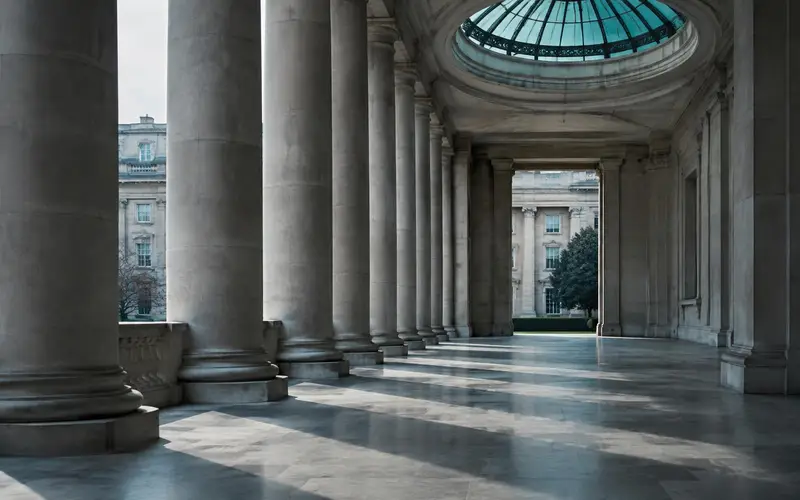 A stone colonnade with no people, under a glass roof lantern